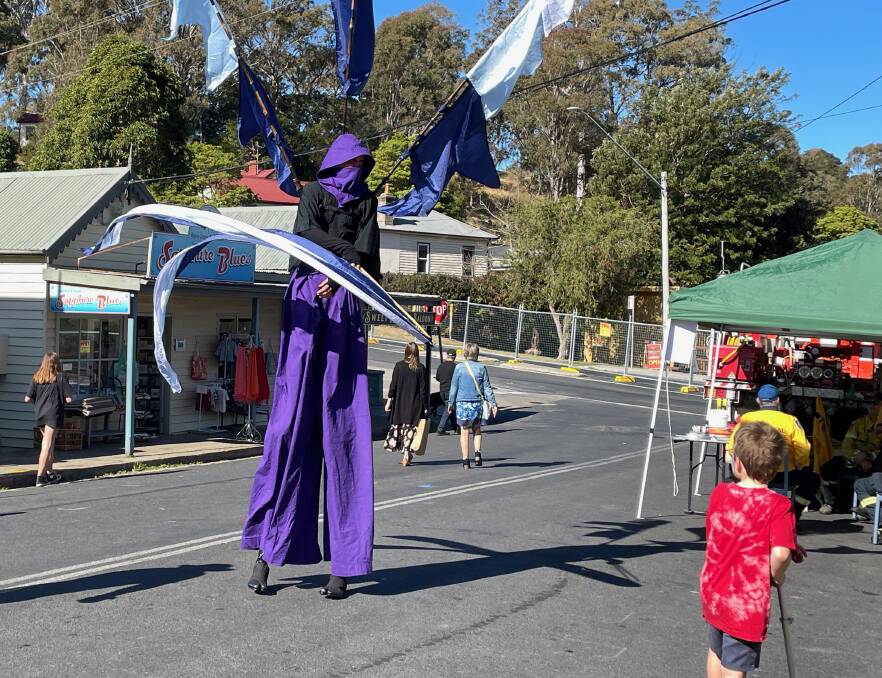 "I come in peace," said the Flag Warrior from Cobargo as he made his way down Bate Street on stilts. Picture by Marion Williams