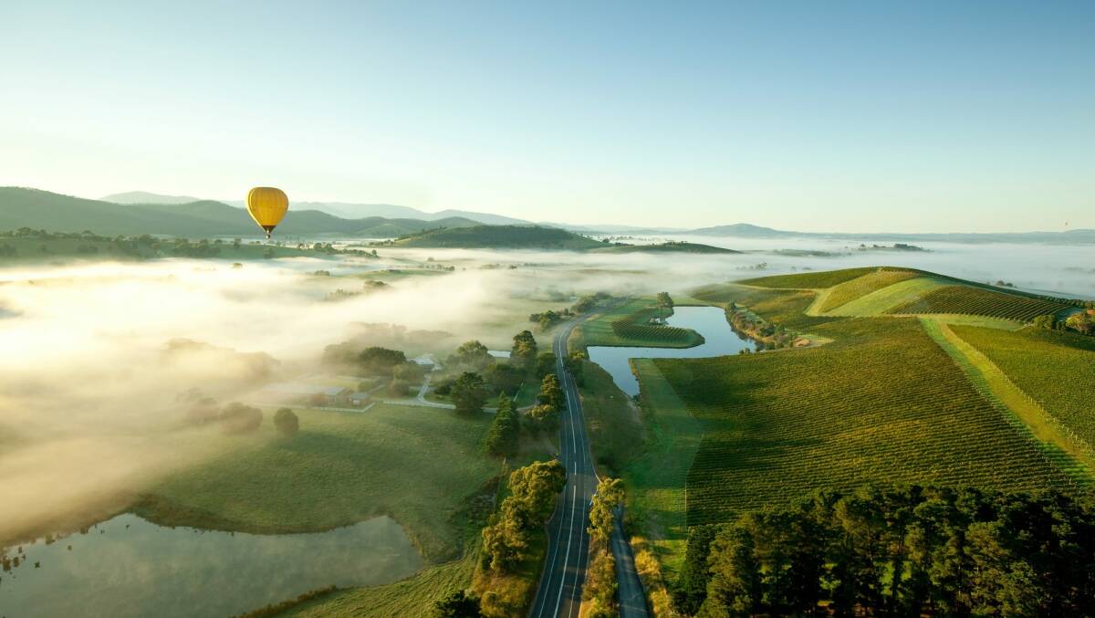 A hot air balloon drifts over the Yarra Valley en route to Balgownie Estate. Picture Global Ballooning 