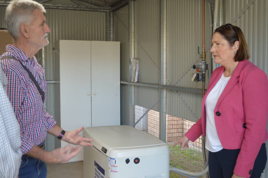 Uniting Church haven project manager Greg Thexton discusses the church's new back-up generator with Ms Phillips.