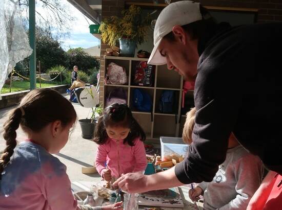Sebastian guides a couple of youngsters at the Lyrebird Preschool where he works to teach art, after completing art studies at TAFE. Pictures supplied. 