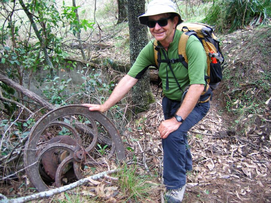 Going for gold: Bushwalker Barry Keeley inspects a wheel and pit, relics from early mining activities in the Moruya region.